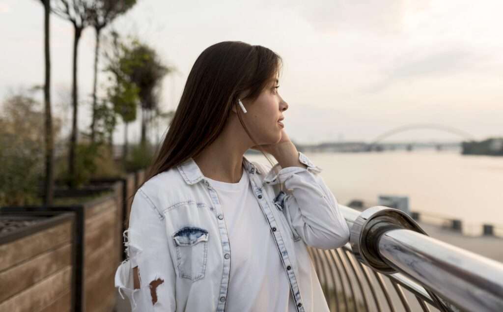 A girl watching sun set with listening music with Airpods